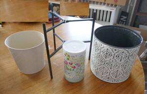 2 metal planters, a folding stand and a can of flower seeds