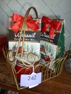 3 packages of spiced cider and a candle in a metal heart shaped basket