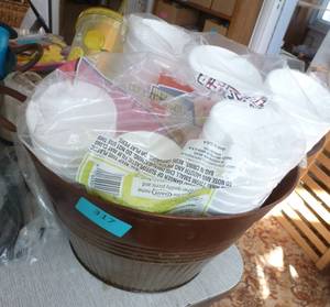 Metal bucket full of styrofoam cups and plates
