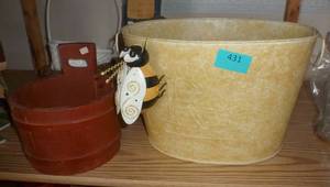 large metal basket planter with a bee hanging on the side, plus a wood planter