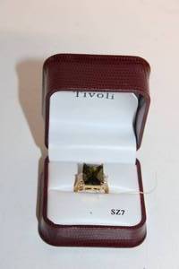 lot A-91 image: Elegant Gold Ring with Green and White Stones in Display Case