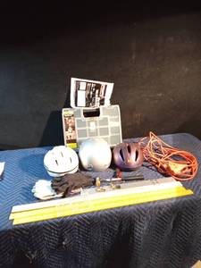 lot 192 image: Box of bicycle helmets, Stanley hardware organizer case, extension cord, rubber hammer, padlocks with keys, work gloves, flashlight, drop cloth, metal and wood yard sticks