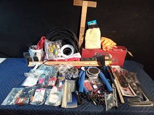 lot 191 image: Box of hardware, metal and wood yardsticks, picture hanging hardware, car vacuum, extension cords, casters, and more