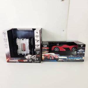 lot 16 image: Lot Of Two New Toys Sharper Image Thunder Twist Remote Control And Turbo Racer 124 Scale Wheel Controller