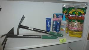 lot 93 image: Two hand garden hoes, river rock, gloves in a bottle, bug spray