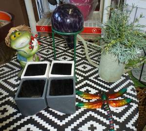lot 242 image: FOUR planters, tin dragonfly, frog, gazing ball stand, plant waterer and grasses in a watering can planter