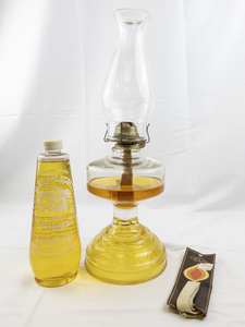 lot 23 image: Group of 3 - P&A Risdon Amber Glass Base with Scroll Eagle Burner, Lamplight Farms Lamp Apple Pie Lamp Oil, & Oil Lamp Wick