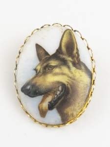 lot 127 image: Porcelain German Sheperd Cameo Gold Tone Base Metal Brooch .