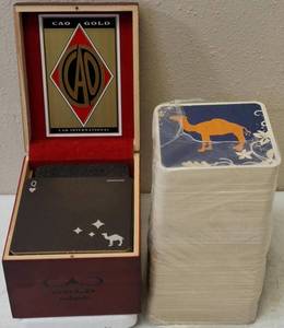 lot 48 image: CAO Gold Cigar Box Converted into a Coaster Holder with Camel Cigarette Coasters & Package of Our Best Smoke Ever Camel Cigarette Coasters (View Photos)