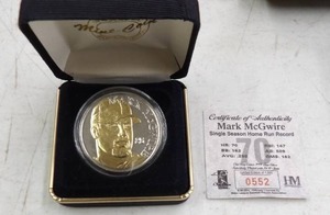 lot 214 image: MARK MCGWIRE SINGLE SEASON HOMERUN RECORD 70 1 TROY OZ. .999 SILVER W 24 KARAT GOLD OVERLAY 1 OF 1500 #0552 HIGHLAND MINT