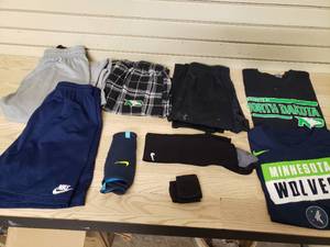 lot 19 image: 2 Under Armour Small sweat pants, 1 UND Medium T-Shirt, 1 Small Wolve T-shirt, 1 sweat pants UND Small, 1 pair shin guards 1 pair socks Shin Gaurds