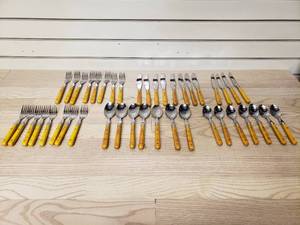 lot 22 image: Bakelite Butterscotch Silverware 7 big spoons, 7 small spoons, 8 small forks, 8 big forks, 8 table knives, 4 steak knives