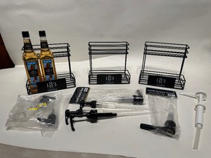 lot 17 image: Metal Syrup Holder Stands, Pumps, and (2) Bottles of Hazelnut Syrup