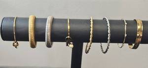 lot 95 image: Assorted Set of Gold Tone and Silver-Toned Bangles and Bracelets - display not inc