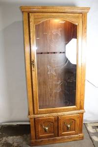 lot 7 image: Rustic Oak Display Gun Cabinet with Glass Door and Deer Accents