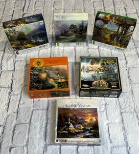 lot 17 image: New Puzzle Collection - Thomas Kinkade, Terry Redlin, Wizard of Oz and More