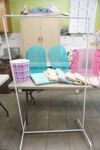 lot 62 image: small clothes rack, storage containers, trash can, and linens