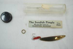 lot 97 image: Vintage The Swedish Pimple Bay De Noc Lure Co. in original packaging.