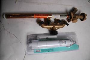 lot 142 image: Assorted Plumbing Supplies Including GE Refrigerator Water Filter, Orbit Hose Faucet Valve, and Copper Pipe