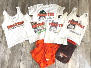 lot 215 image: Hooters Apparel Collection - 5 Tank Tops, 3 Pair Shorts, and 1 Apron