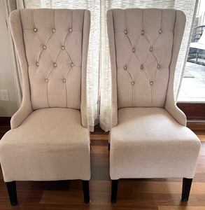 lot 8A image: Pair of Elegant Beige Wingback Dining Chairs with Button Tufting #1