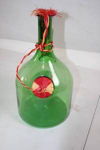 lot 260 image: Large Green Glass Decorative Bottle with Red Raffia Accents
