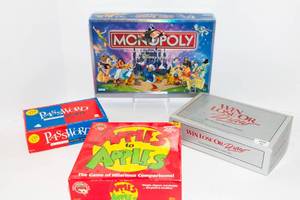 lot 15 image: Four Board Games - Monopoly The Disney Version, Password, Apples to Apples, and Win Lose or Draw