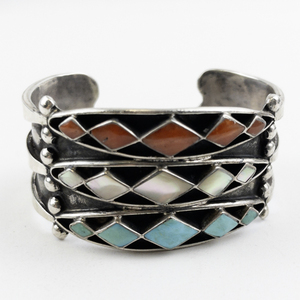 lot 31 image: Zuni Designer Three Row Turquoise, Coral, & Mother Of Pearl Inlaid Sterling Silver Cuff Bracelet.