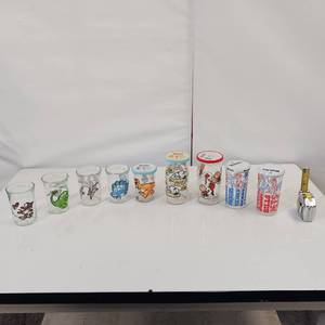 lot 125 image: 9 piece WELCHS Jam Jar Collectible Glasses - some with lids Dinosaurs - Charlie Brown - Snoopy - & 2 sport themed glasses