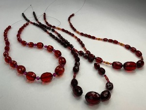 lot 38 image: Three Ruby Red and Cherry Amber Plastic & Crystal Bead Strands