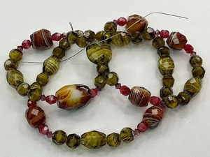 lot 69 image: Faceted Green and Brown Swirl Glass Bead Strand