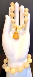 lot 33 image: Pair of Yellow Jade Bead Bracelets with Buddha Charm