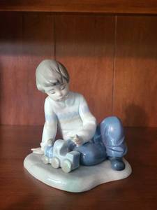 lot 64 image: Nao by Lladro Porcelain Figurine - Boy with Toy Train