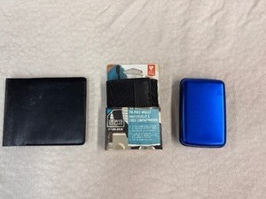 lot 148 image: Three Unused Wallets - Leather, Aluminum and Lewis and Clark Data Block