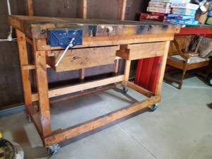 lot 20 image: Large Heavy Sturdy Wooden Work Bench with 2 Drawers and Attached Vise On Wheels NOTICE Buyer is responsible for Loading and Removal 