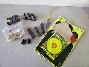 lot 230 image: 45 Auto Ammo, Targets, and Gun Clips with Some Ammo in them, and Gun Lock