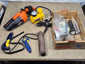 lot 94 image: Lot of Automotive Accessories and Tools including handheld vacuum cleaner, a portable air compressor, a flashlight, and various car accessories.