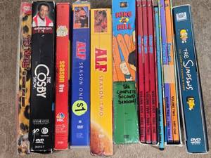 lot 140 image: Lot of TV Show DVD Box Sets such as The Nanny, The Cosby Show, King of the Hill, Saved by the Bell, ALF, Family Guy, and The Simpsons.