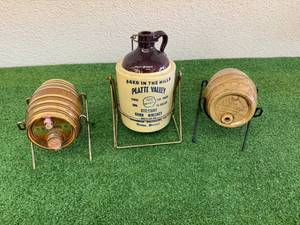 lot 70 image: McCormick Platte Valley Corn Whiskey Jug On Stand & 2 Smaller McCormick Whiskey Bottles on Stands