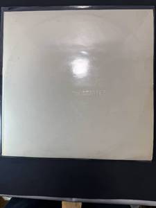 lot 1 image: The Beatles White Album, with rare poster inside as well as four head shots of each band member. This Album is in a protective sleeve. 