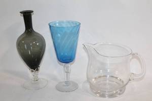 lot 230 image: Set of 3 Art Glass Pieces Black Vase, Blue Wine Glass, and Clear Pitcher