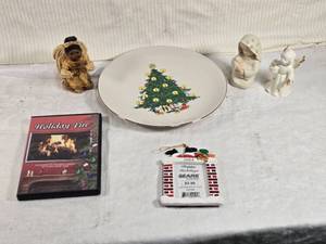 lot 259 image: Holiday Decor and Collectibles Lot - a decorative plate with a Christmas tree design, three angel figurines, a DVD titled Holiday Fire featuring Christmas carols, and a 2004 Sears holiday ornament