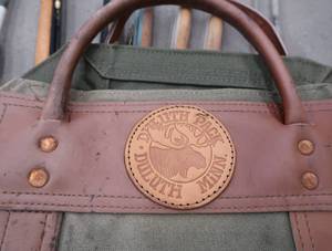 lot 46 image: DULUTH PACK SLING PACK AND VINTAGE ICE FISHING RODS