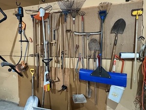 lot 609 image: Garage Wall Full of Yard Tools - Shovels, Rakes, Weed Whippers, Saws, and More