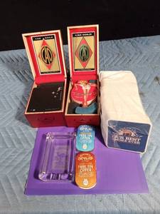 lot 125 image: Camel coasters in 2 CAO gold Corona woods cigar boxes, Camel ashtray, 2 Came snuff tins and a pack of Camel coasters