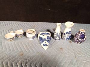 lot 94 image: Pfaltzgraff, 2 measuring cups, 1 blue willow flower wall pocket, 2 blue & white Sake bottles, 1 blue and white vase, 1 Asian Chinoiserie planter