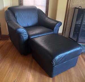 lot 22 image: Sleek Black Faux Leather Chair with Ottoman