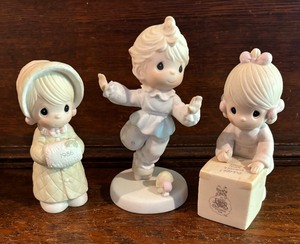 lot 79 image: Precious Moments Figurines including Sharing is Universal, Happy Trip and Wishing You a Cozy Christmas