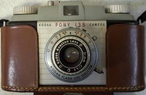 lot 45 image: Vintage Kodak Pony 135 Camera  Kodak Flash Holder, Sylvania Flashbulbs, RCA Service Parts - 110905 Spindle 45 RPM & Kodachrome Color Safety Film - Type F Box  Container (Empty) View Photos