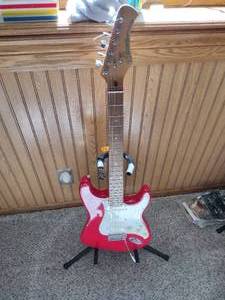 lot 9 image: Hondo Red Guitar with Stand